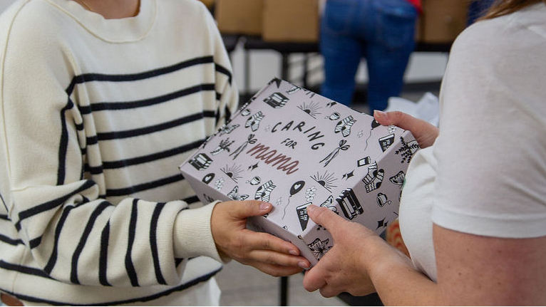 Mom receiving a Caring for Mama care box during a packing event with Target.